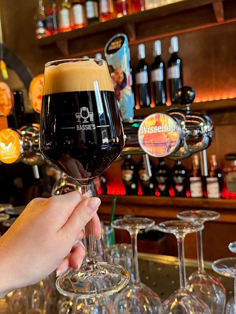 Een donker bier in een Bassie's-glas aan de bar